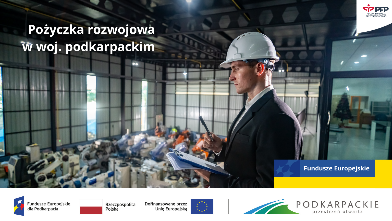 Mężczyzna w garniturze i kasku ochronnym stoi na antresoli w hali przemysłowej, trzymając długopis i dokumenty. W tle widoczne maszyny i urządzenia przemysłowe. Na grafice widnieje napis „Pożyczka rozwojowa w woj. podkarpackim” oraz logotypy Funduszy Europejskich, Rzeczypospolitej Polskiej, Unii Europejskiej, województwa podkarpackiego i Polskiej Fundacji Przedsiębiorczości.