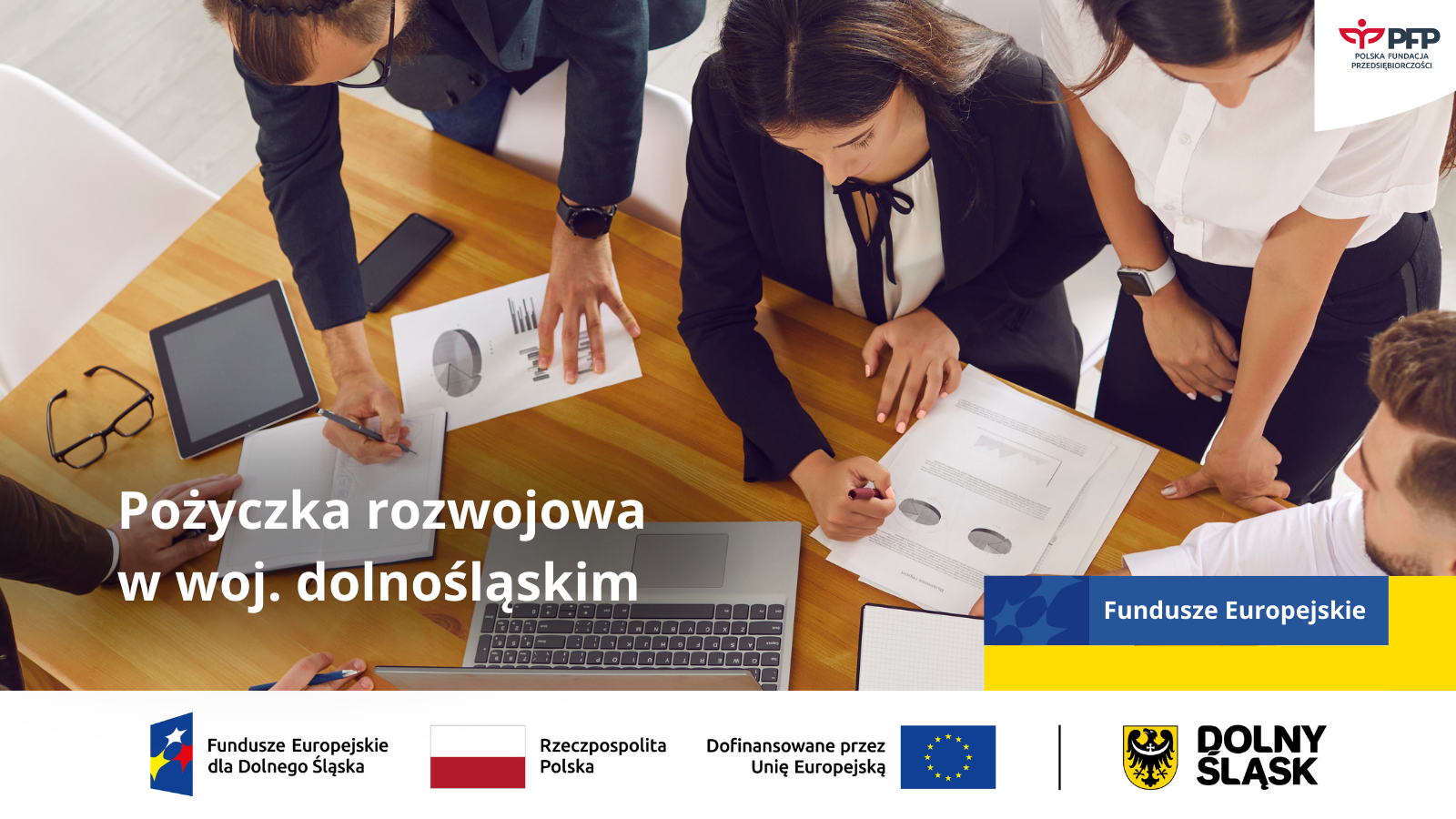 Na zdjęciu widzimy osoby pracujące przy stole – analizują dokumenty i wykresy, korzystając z laptopa i tabletu. Grafika promuje Pożyczkę Rozwojową w województwie dolnośląskim. W dolnej części znajdują się logotypy: Fundusze Europejskie dla Dolnego Śląska, Rzeczpospolita Polska, Unia Europejska oraz Dolny Śląsk.