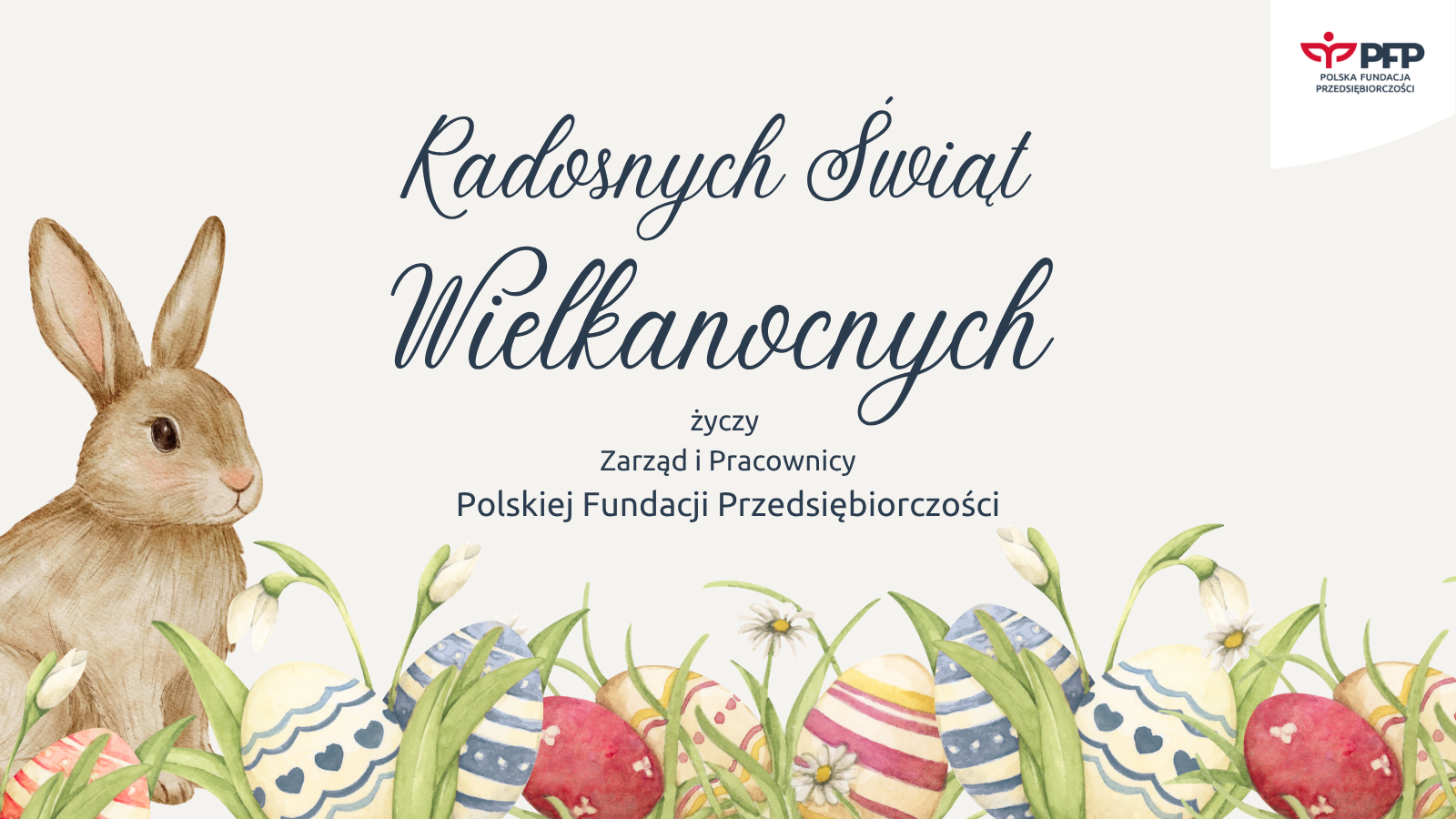 Rysowany królik wśród trawy i kolorowych pisanek, pośrodku napis Radosnych Świąt Wielkanocnych, poniżej życzy Zarząd i Pracownicy Polskiej Fundacji Przedsiębiorczości; w prawym górnym rogu logo PFP Polska Fundacja Przedsiębiorczości.